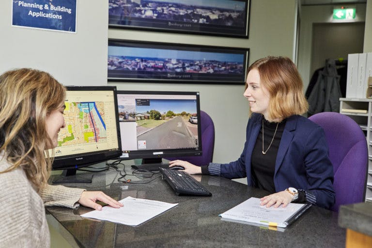 woman and employee looking at map and papers