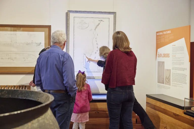 Museum guide shows family point on a map