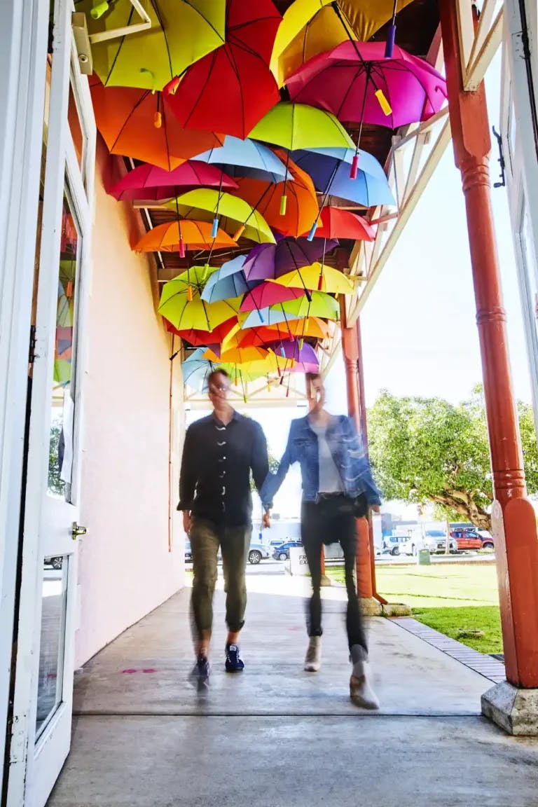 two people walking under colourful verandah ceiling decorations