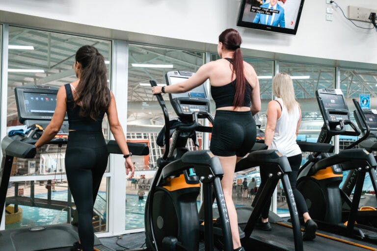 Three women on cardio machines in gym